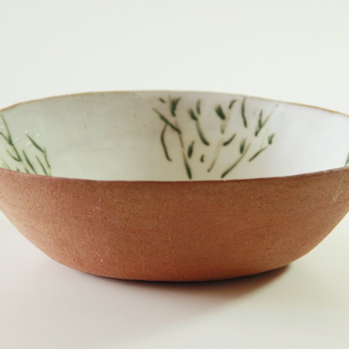 A red clay bowl with leaf brushwork