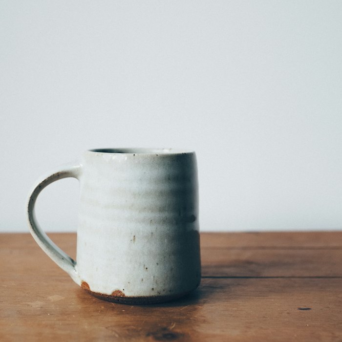 A pale blue mug on a wooden table