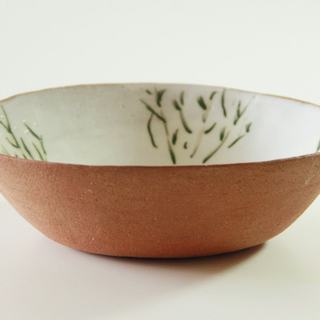 A red clay bowl with leaf brushwork